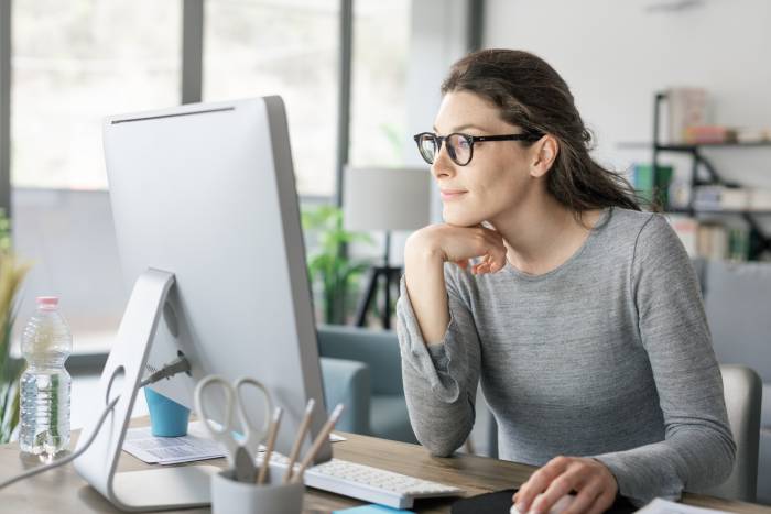 Professional woman working from home Professional woman sitting at desk and connecting with her computer, she is working from home